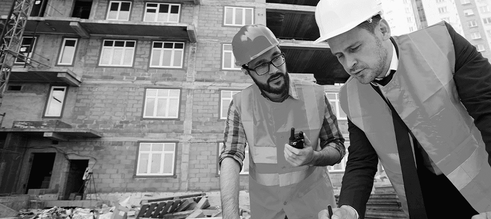 Construction professionals reviewing blueprints on site